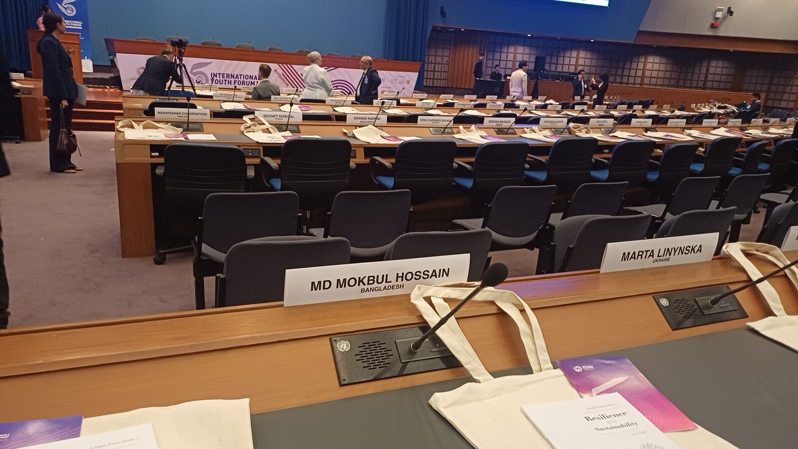 A delegate nameplate reading "MD MOKBUL HOSSAIN, BANGLADESH" at a United Nations conference desk